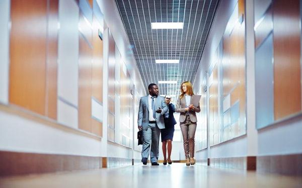 Business people walking down the office corridor and communicating